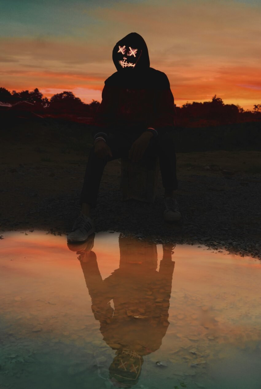 Man Sitting on Box Near Puddle